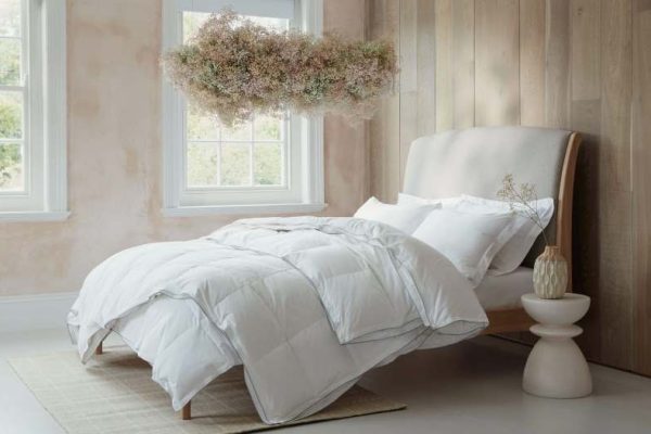 Plush white goose down hotel pillow on luxury bed with soft morning light