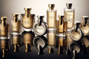 A collection of Bvlgari perfume bottles arranged on a reflective surface with soft lighting