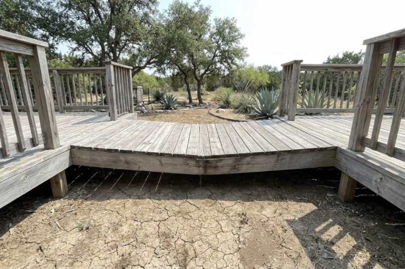 Inspecting sagging wooden deck framing in Austin TX